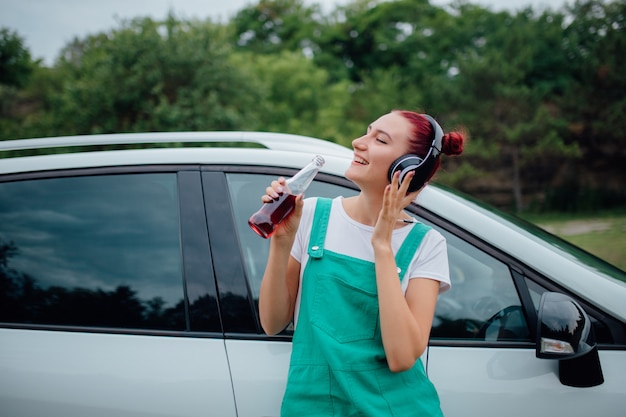 Jeune fille, à, écouteurs, écouter musique, côté, voiture