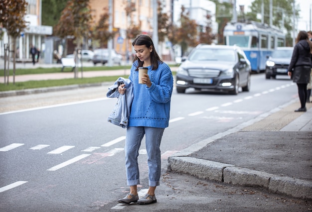 Jeune fille élégante avec du café pour se promener dans la ville