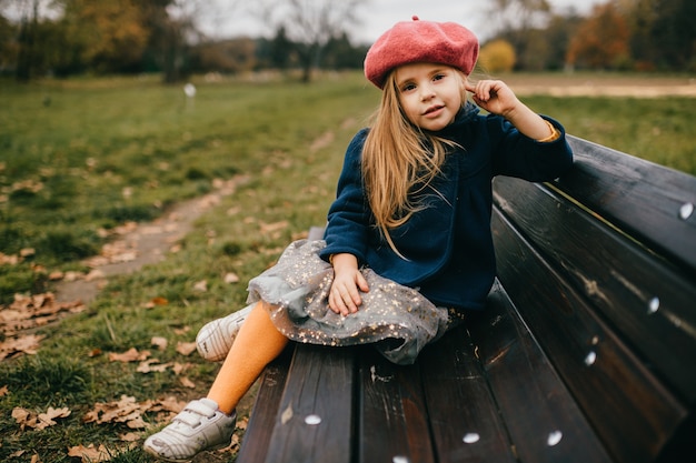 Une jeune fille élégante posant sur le banc