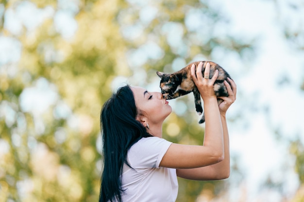 Jeune fille embrasse chaton dans la nature