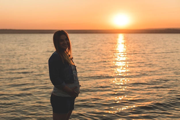 Jeune fille enceinte sur la silhouette de la plage