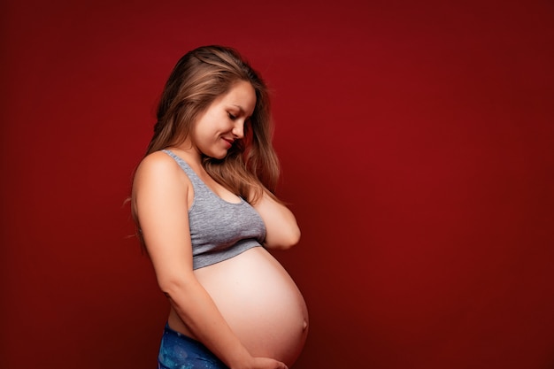 jeune fille enceinte Sportswear sur fond rouge