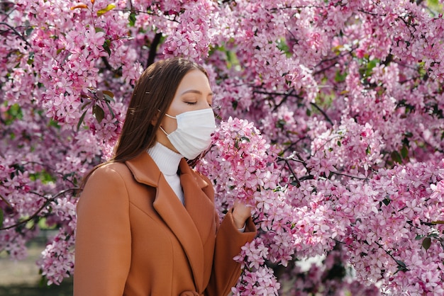 Une jeune fille enlève son masque et respire profondément après la fin de la pandémie un jour de printemps ensoleillé