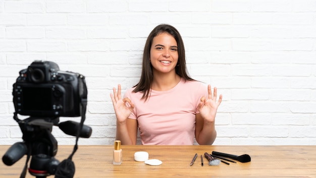 Jeune fille enregistrant un tutoriel vidéo montrant un signe ok avec les doigts