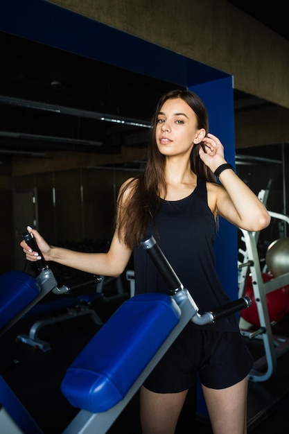 Jeune fille entraîneur effectue des exercices dans un club de gym moderne