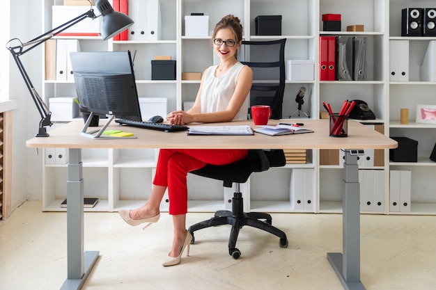 Une jeune fille est assise au bureau du bureau.