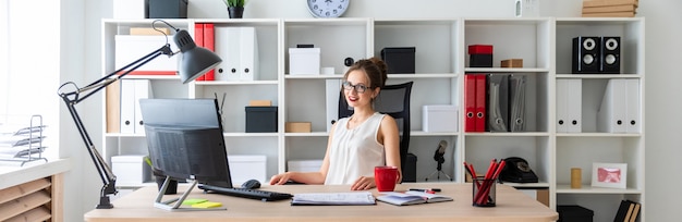 Une jeune fille est assise au bureau du bureau.