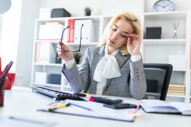 Une jeune fille est assise à une table dans le bureau