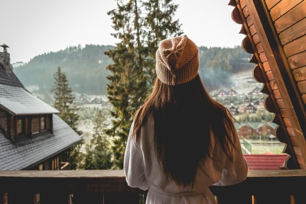 La jeune fille est debout sur une maison mitoyenne dans une région montagneuse Par beau temps hivernal