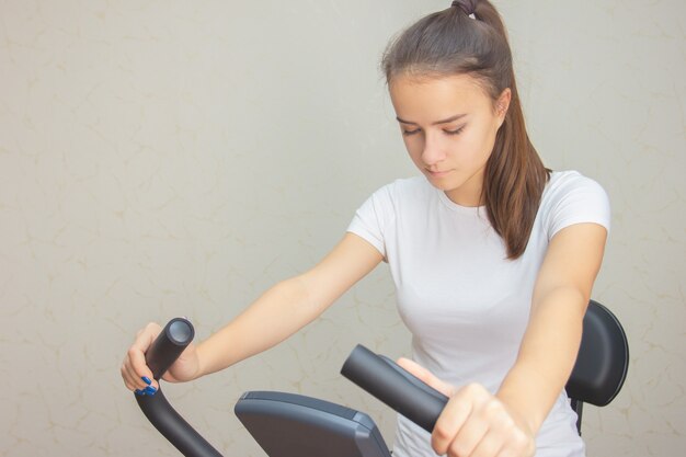 La jeune fille est engagée sur un vélo stationnaire à la maison