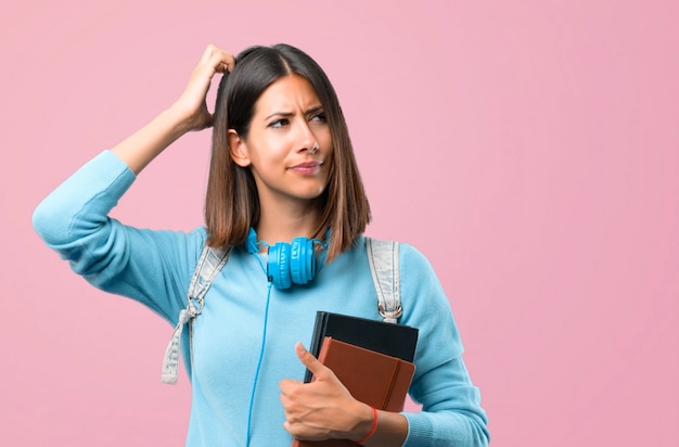 Jeune fille étudiante avec un pull bleu et un casque ayant des doutes. retour à l&#39;école