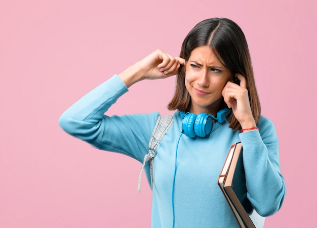 Jeune fille étudiante avec un pull bleu et un casque couvrant les deux oreilles. retour à l&#39;école