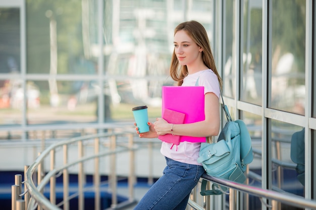 jeune fille étudiante avec une tasse de café dans la rue