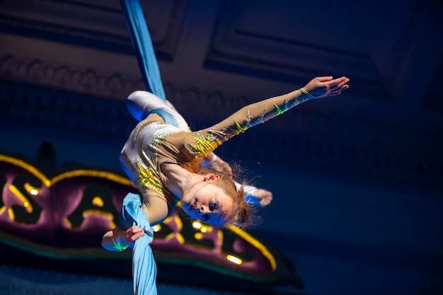 La jeune fille exécute des numéros acrobatiques sur les toiles