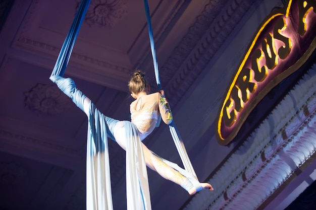 La jeune fille exécute des numéros acrobatiques sur les toiles