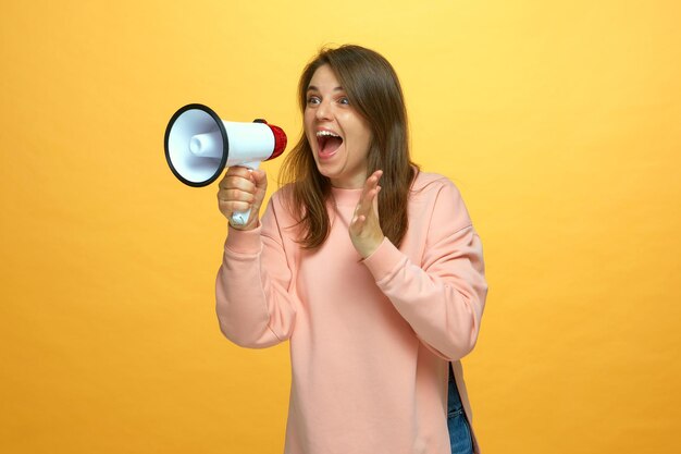 Une jeune fille expressive crie dans un haut-parleur est sortie d'une femme criant dans un mégaphone de grandes remises en vente