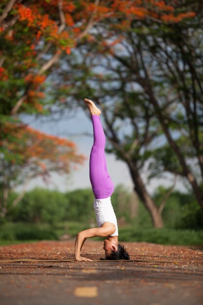 Jeune fille faire du yoga dans le parc