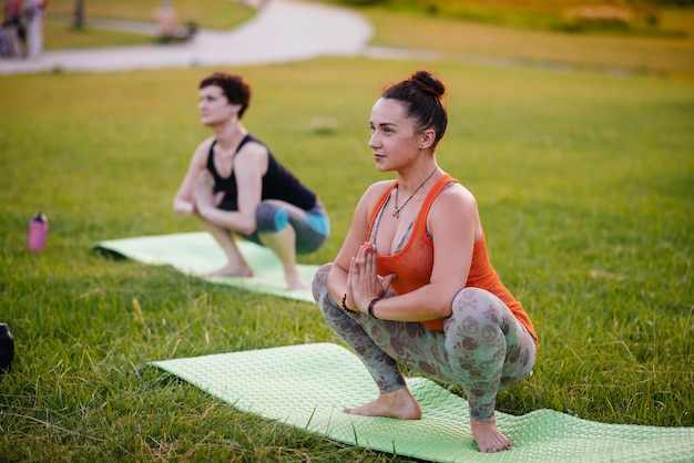 Jeune fille faisant du yoga en plein air, dans le parc au coucher du soleil. Mode de vie sain