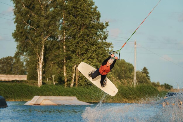 Une jeune fille fait du wakeboard et fait différents tours de planche.