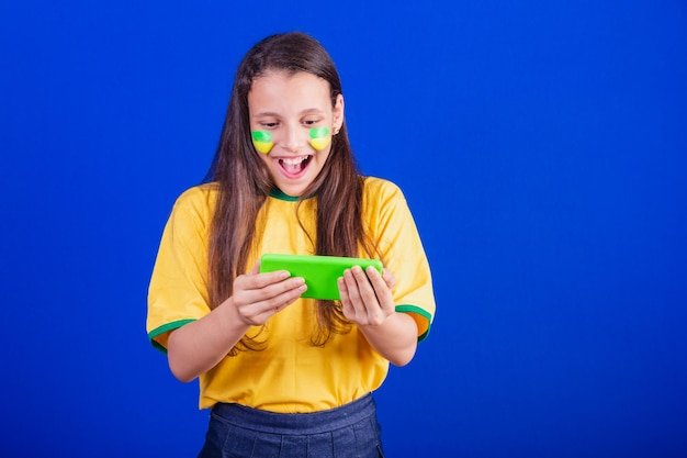 Jeune fille fan de football du Brésil holding cellphone surpris applications Smartphone