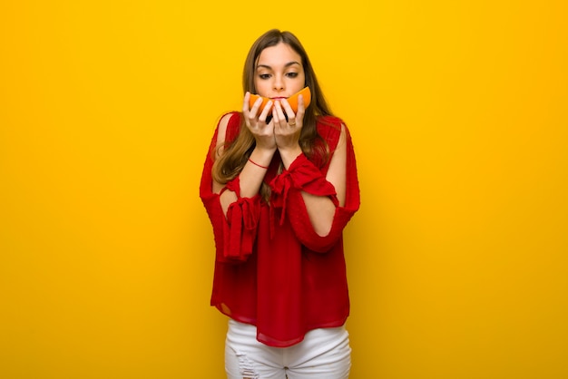 Jeune fille sur fond jaune vibrant avec des oranges