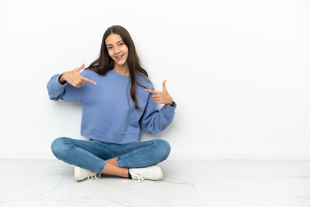 Jeune fille française assise sur le sol fière et satisfaite d'elle-même