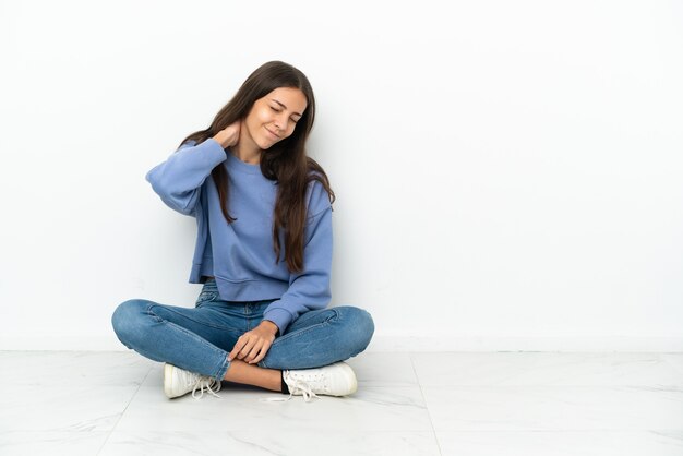 Jeune fille française assise sur le sol avec mal au cou