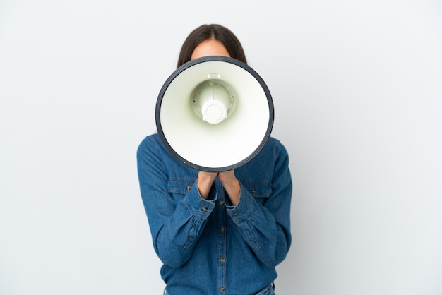 Jeune fille française isolée sur fond blanc criant à travers un mégaphone pour annoncer quelque chose