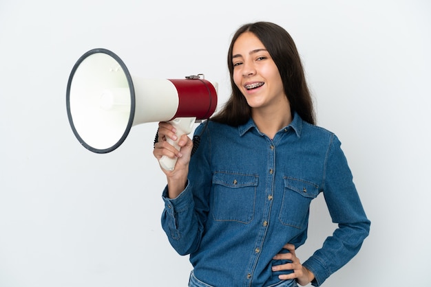 Jeune fille française isolée sur fond blanc tenant un mégaphone et souriant