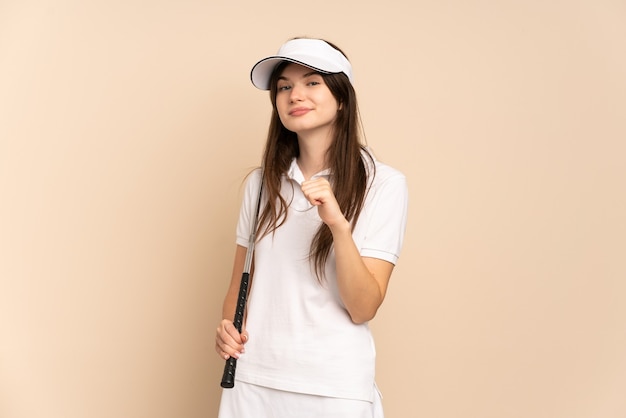 Jeune fille de golfeur isolée sur beige fier et satisfait de soi