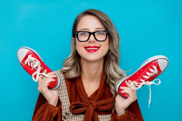 Jeune fille avec des gommes rouges sur bleu