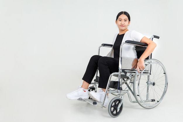 Jeune fille handicapée asiatique sur le sourire en fauteuil roulant de l'hôpital et regardant la caméra.