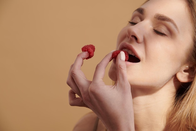 Photo jeune fille heureuse avec des fraises fraîches