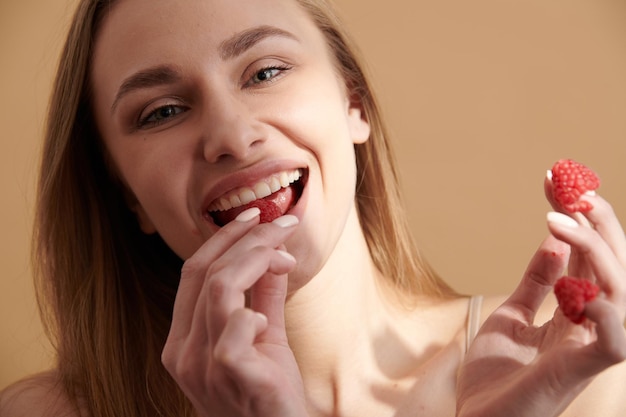 Photo jeune fille heureuse avec des fraises fraîches