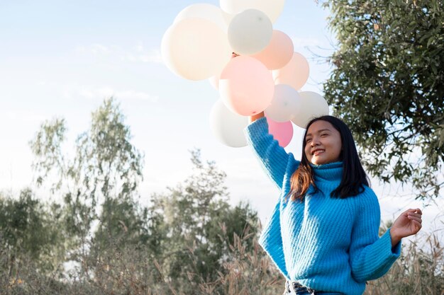 Une jeune fille heureuse tient un ballon à la prairie en hiver.