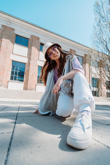 Jeune fille hip hop en tenue surdimensionnée portant la danse dans la musique fond urbain minimaliste hipho