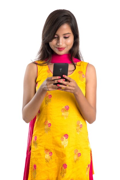 Jeune fille indienne à l'aide d'un téléphone mobile ou d'un smartphone isolé