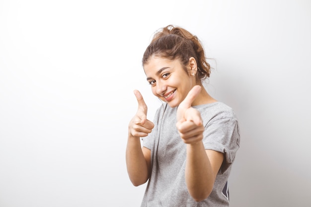 Jeune fille indienne souriante pointe les doigts vers la caméra.