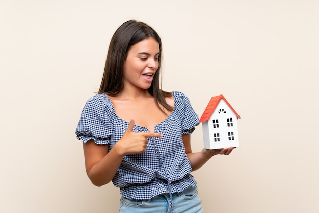 Jeune fille, sur, isolé, mur, tenue, a, petite maison