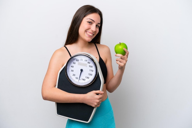 Jeune fille isolée sur fond blanc avec balance et avec une pomme