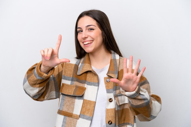 Jeune fille isolée sur fond blanc comptant sept avec les doigts