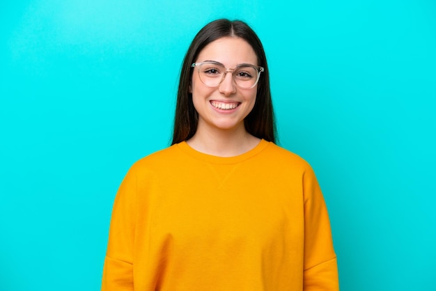 Jeune fille isolée sur fond bleu avec des lunettes avec une expression heureuse