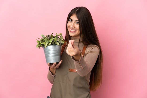 Jeune fille de jardinier tenant une plante isolée