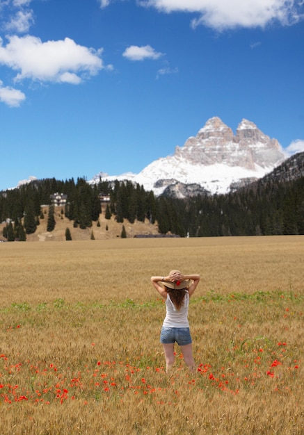 Jeune fille joies sur le champ de blé et les montagnes en arrière-plan