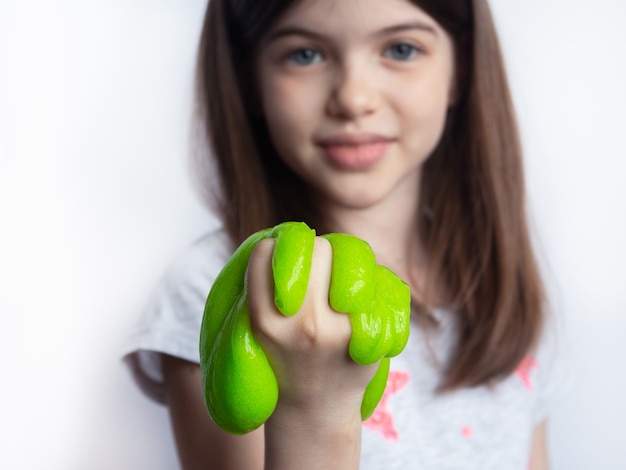 jeune fille jouant avec de la boue verte