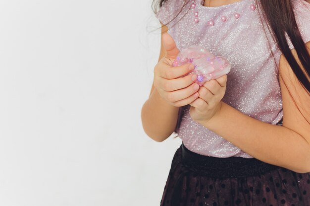 Jeune fille jouant avec du slime. Isolé sur fond blanc.