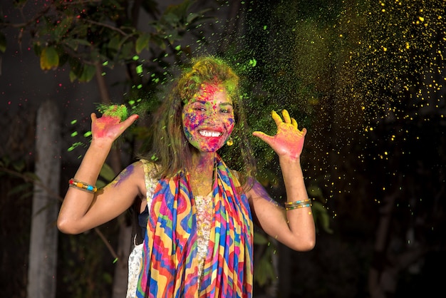 Photo une jeune fille joue avec les couleurs. le concept du festival indien holi. tâche de couleur.