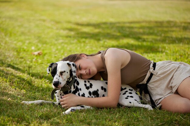 Une jeune fille joue avec un dalmatien dans le concept de soins pour chiens du parc