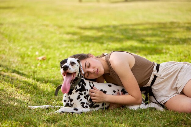 Une jeune fille joue avec un dalmatien dans le parc.