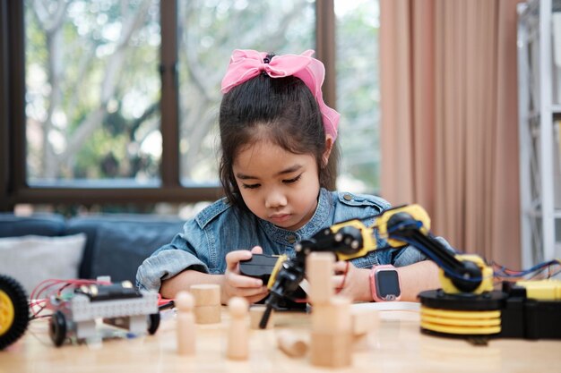 Une jeune fille joue avec une télécommande, un robot.